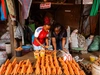 Christine Ng’ang’a, Co-founder of Soko Kijiji working with a vegetable stall owner, sorting through stacks of carrots.