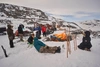 A group of people sitting around a large outdoor fire, in a snowy area, for EntrepreNorth