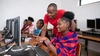 Two young people working at a computer station together.