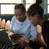 Two women working on a laptop together