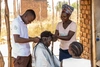 William braiding hair at the Village No 7 Rhino Refugee Camp