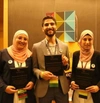 Three people standing holding plaques