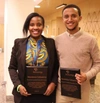 Edith Violet Naisubi and Amanuel Eshete at the 2019 Baobab Summit stood facing and smiling to camera holding plaques