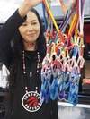 A smiling woman holding Indigenous beadwork.