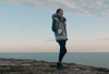 Woman standing by the water in a winter coat