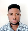 Kwawuvi Joshua Elorm wearing a button up blue, light blue and white patterned button up shirt