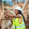 Gisele Umulisa travaille sur un chantier de construction avec un casque et un gilet de haute visibilité
