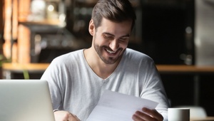 man smiling looking at letter