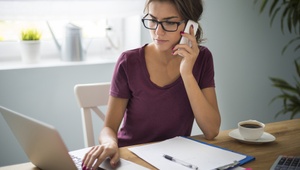 woman on phone sat at desk