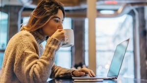 young woman on laptop drinking coffee