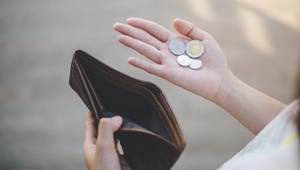 woman looking at coins left in purse