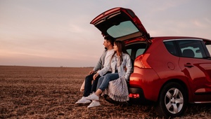 couple on a trip sitting on the carboot