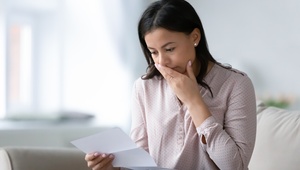 distressed woman looking at bills