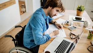 man in wheelchair filing in paperwork