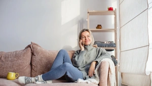 relaxed woman sitting on the sofa on her mobile phone