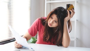 worried woman holding credit cards
