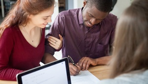 couple signing agreement at bank