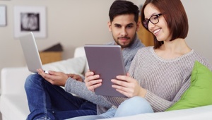 couple on sofa looking at laptop