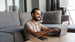 smiling man on laptop in his lounge