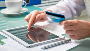 man using tablet with a credit card