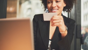 woman with a credit card at a desk