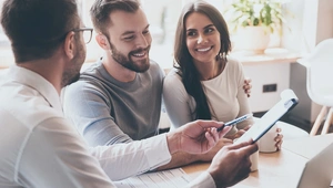 A couple sit with their solicitor reviewing paperwork