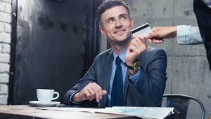 man in suit having coffee paying with a credit card