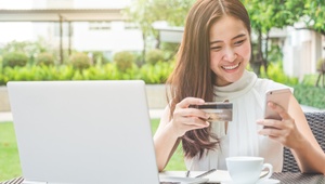 woman on laptop with card and phone