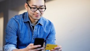 man holding credit card and phone