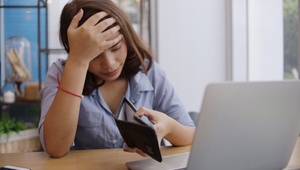 unhappy woman with no money in purse
