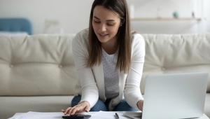 woman using calculator and laptop
