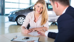 Woman signing car finance 