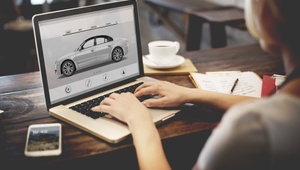 woman at laptop looking at car