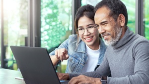 daughter and father on laptop