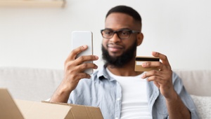 smiling man holding credit card