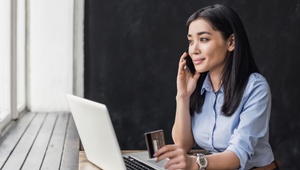 woman on mobile holding credit card