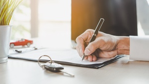 man signing car contract