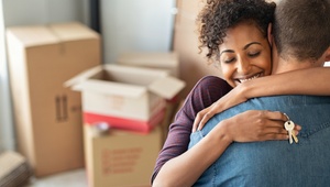 couple hugging with house keys in hand