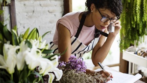 woman talking to customer on phone in florist