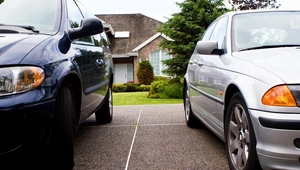 two cars parked outside of a house
