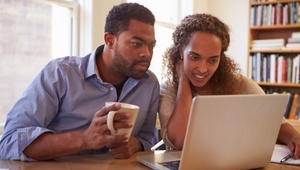 couple reading on laptop