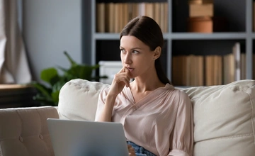 Woman with laptop considering a purchase