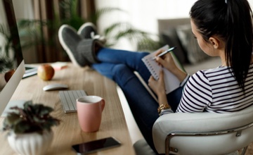 Woman at desk creating a list of her bills
