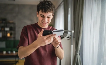 Young man with a credit card in his hand and a mobile phone
