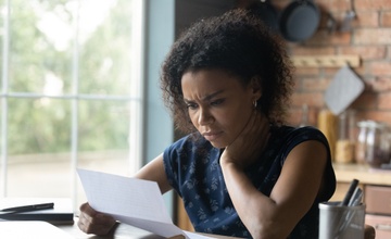 Woman reading letter from a debt collection agency