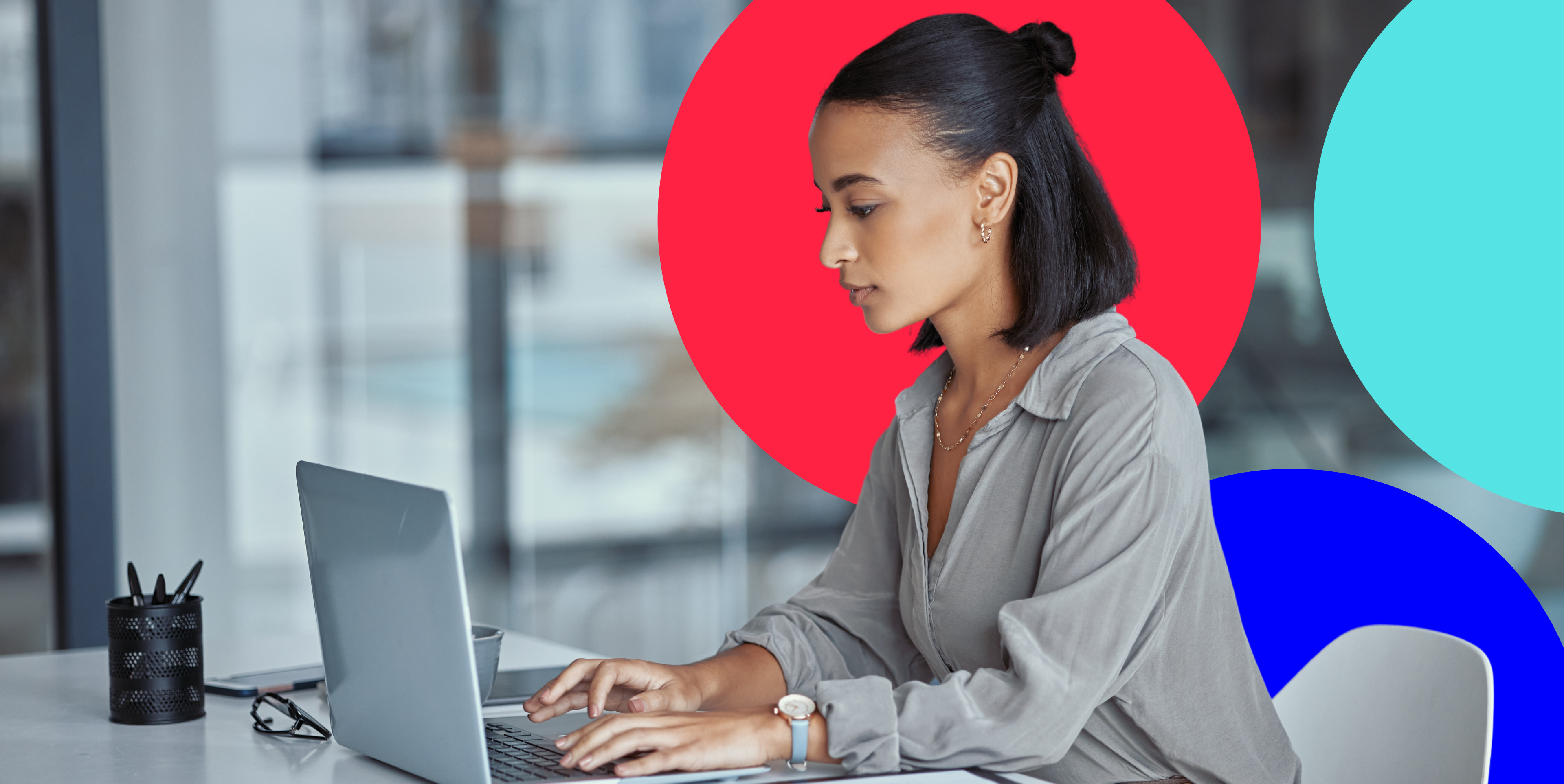 black woman sitting at a desk with a laptop typing