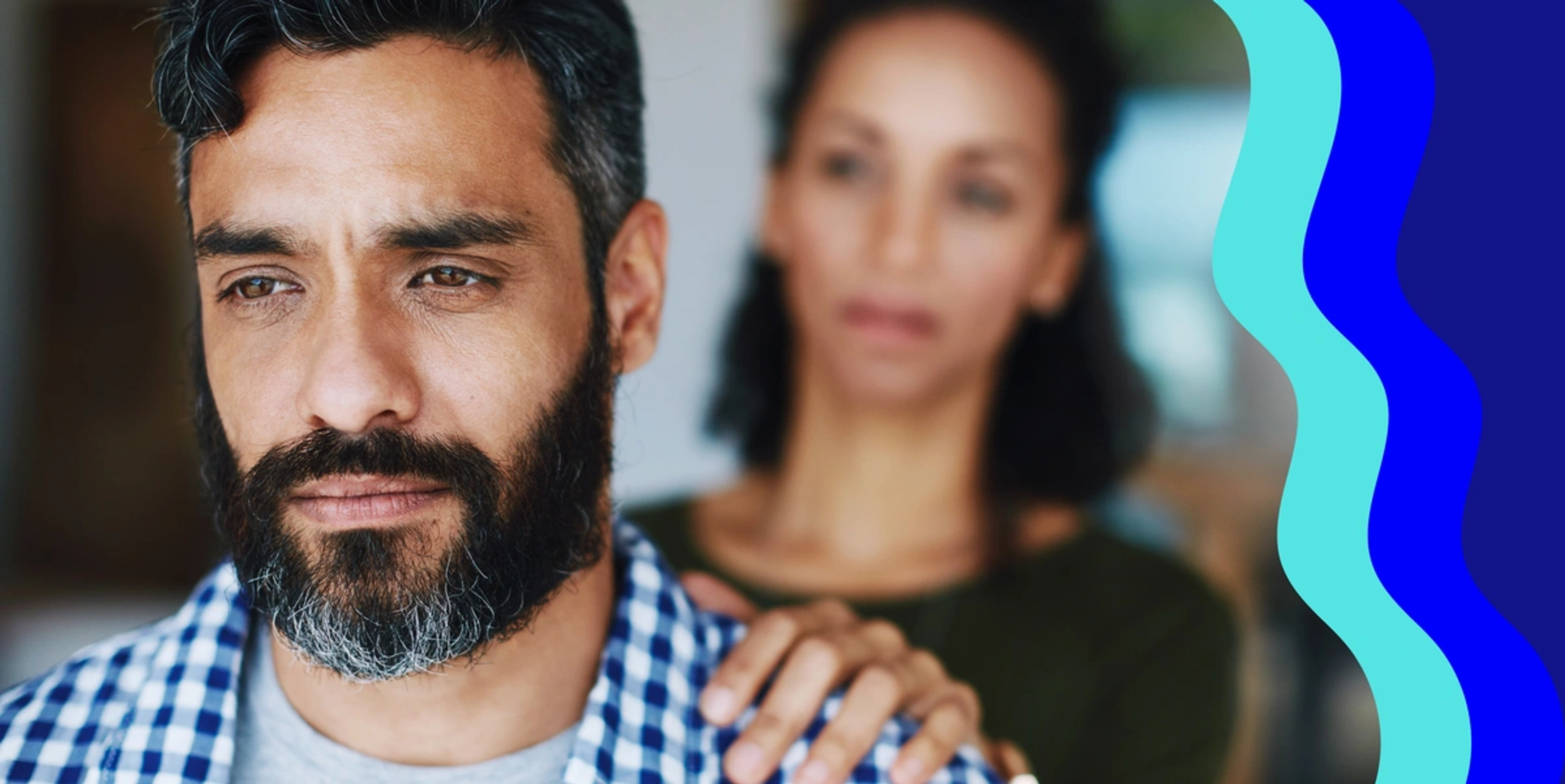 Image of man looking off in the distance with woman holding his shoulder comforting him after a layoff