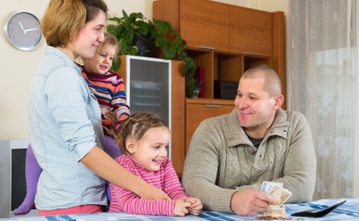 Family counting cash at the dining table.