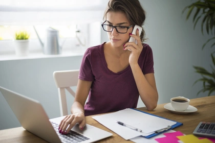 woman on phone sat at desk