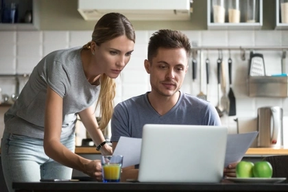 couple on laptop in kitchen